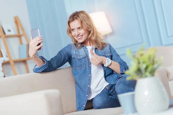 Lachende jonge vrouw een gerust gevoel tijdens het nemen van een foto van zichzelf — Stockfoto