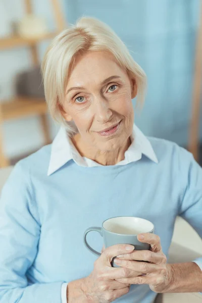 Angenehme Seniorin fühlt sich beim Trinken von heißem Tee ruhig — Stockfoto