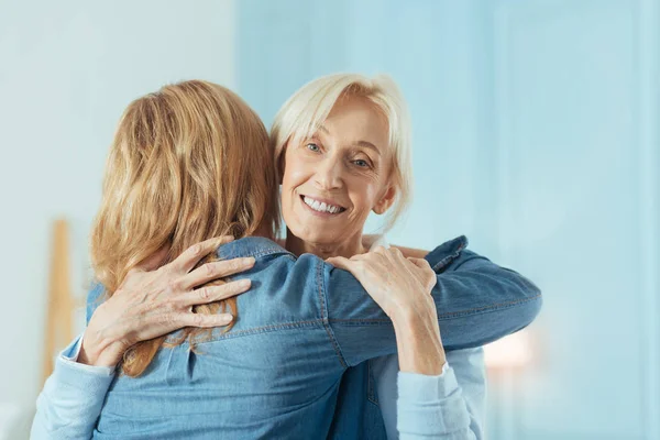 Polite aged woman hugging her young cute granddaughter — Stock Photo, Image