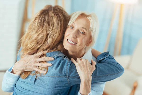 Эмоциональная пожилая женщина чувствует себя хорошо при встрече с внучкой — стоковое фото