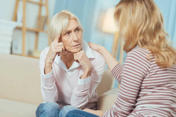 Mujer anciana pensativa que parece preocupada y frunciendo el ceño — Foto de Stock