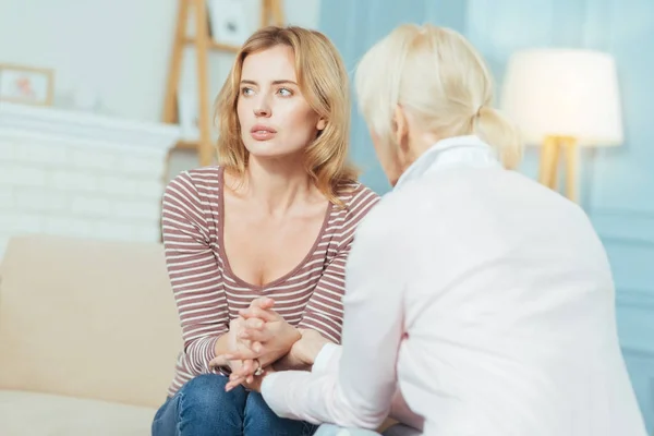 Upset young woman looking into the distance while her granny comforting her — Stock Photo, Image