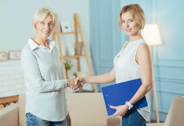 Conselheiro financeiro inteligente apertando as mãos com seu cliente grato e sorrindo — Fotografia de Stock