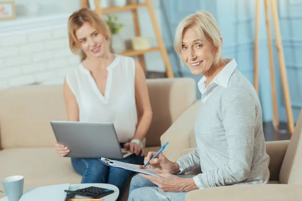 Positiv pensionär kontrollera handlingarna och leende — Stockfoto