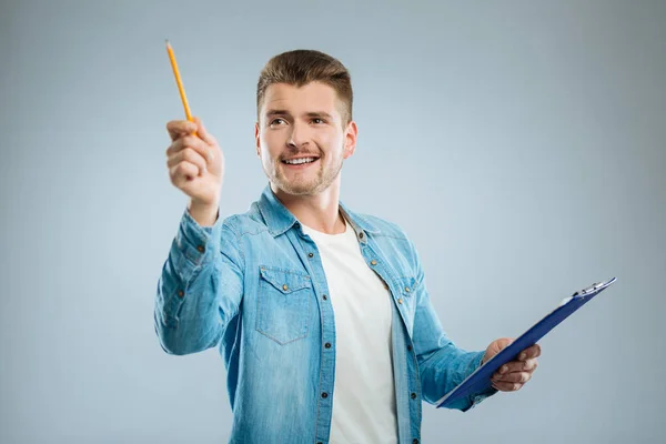 Attentive brunette looking at his pencil — Stock Photo, Image