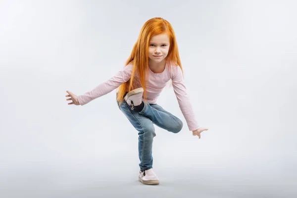 Geconcentreerde meisje staande op een been — Stockfoto