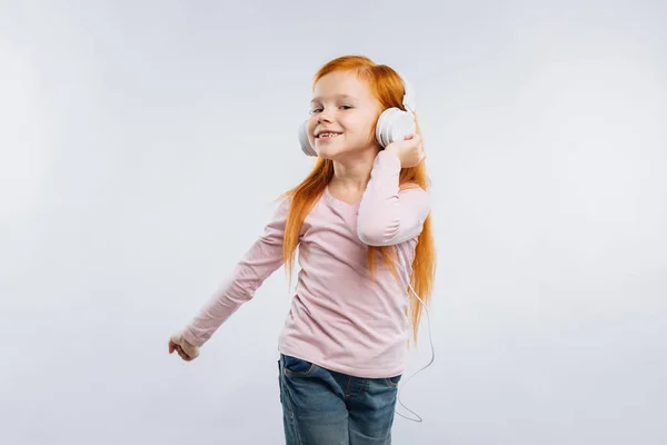 Criança engraçada tocando seus fones de ouvido — Fotografia de Stock