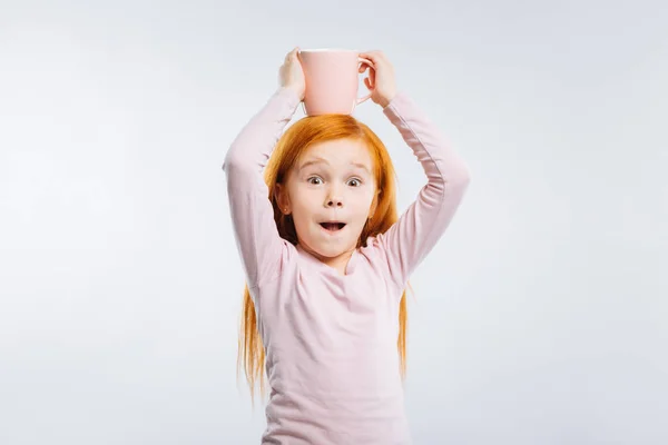 Alegre niña poniendo taza en su cabeza —  Fotos de Stock