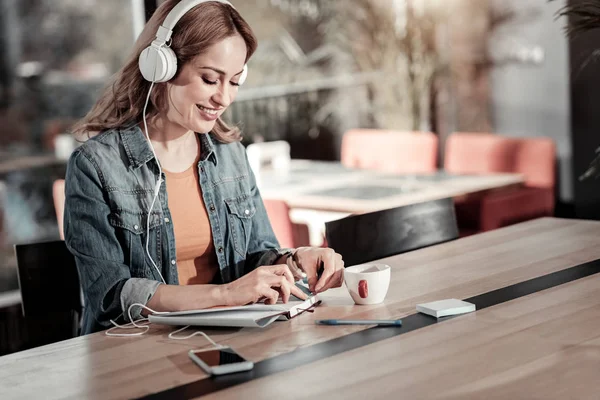 Mujer joven sonriente teniendo una mañana productiva en un café —  Fotos de Stock