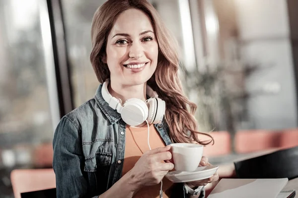 Leende ung kvinna stå och hålla en kopp kaffe — Stockfoto