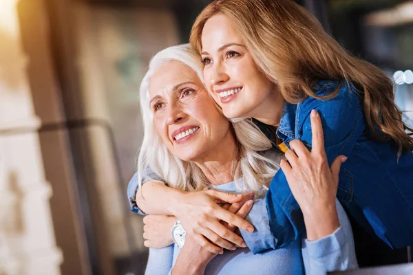 Två glada kvinnor i olika ålder tittar in avståndet — Stockfoto