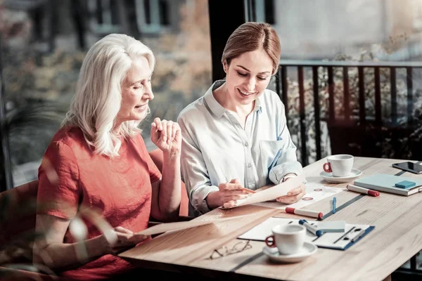 Glada äldre kvinna tittar på ritningen en ung erfaren designer — Stockfoto