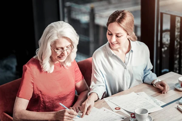 Glada leende kvinna som pekar för en signatur — Stockfoto