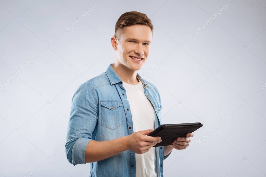 Handsome man holding his gadget