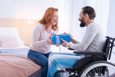 Felçli adam ve hediye tutan mutlu bir kadın