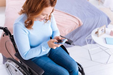 Gülümseyen özürlü kadın telefonunu kullanarak