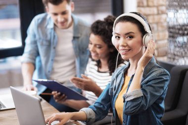 Kulaklıklar giyen ve dizüstü bilgisayarda çalışan içerik kız