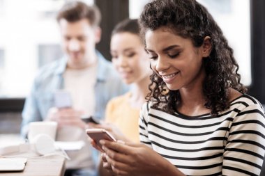 Oturma ve telefonunu kullanarak neşeli kız