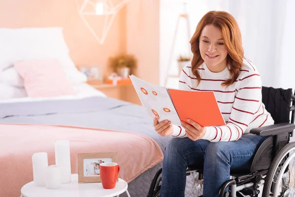 Mujer discapacitada alegre leyendo en la silla de ruedas — Foto de Stock