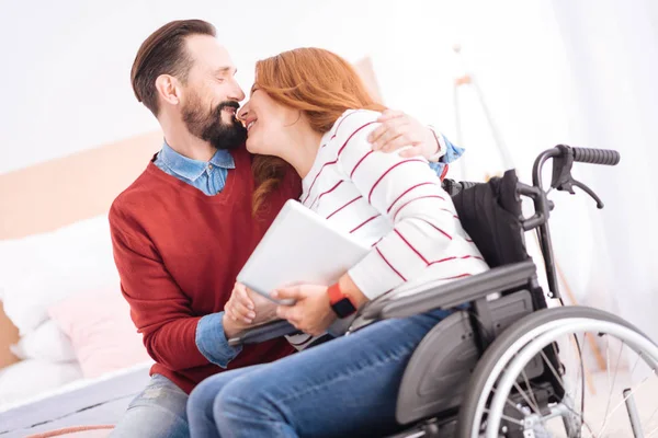 Feliz hombre sonriente abrazando a su mujer discapacitada — Foto de Stock