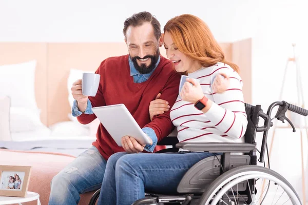 Carefree man and handicapped woman using a tablet — Stock Photo, Image