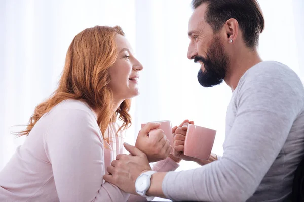 Lachende vrouw en man kijken elkaar met cups — Stockfoto