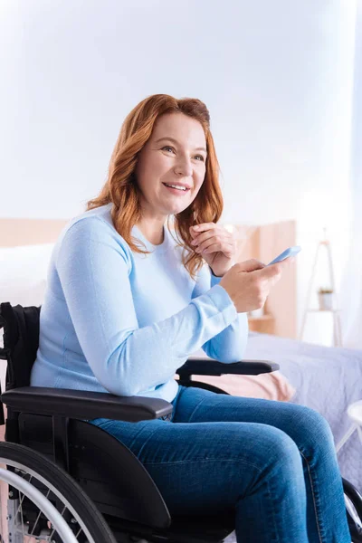Радісна паралізована жінка тримає свій телефон — стокове фото