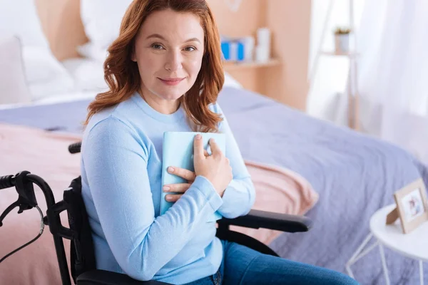 Mujer paralizada bastante sonriente sosteniendo un libro — Foto de Stock