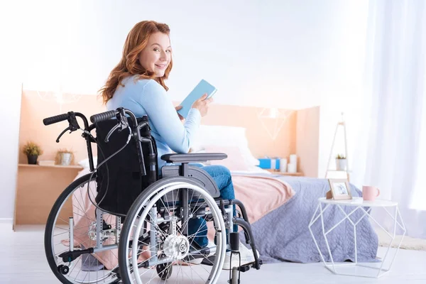 Feliz boa aparência sorridente paralisada mulher segurando um livro — Fotografia de Stock
