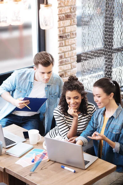 Aspiring man and two girls sitting at the table — Stock Photo, Image