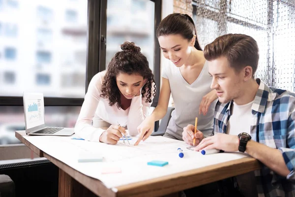 Content man and two ladies making a technical drawing — Stock Photo, Image
