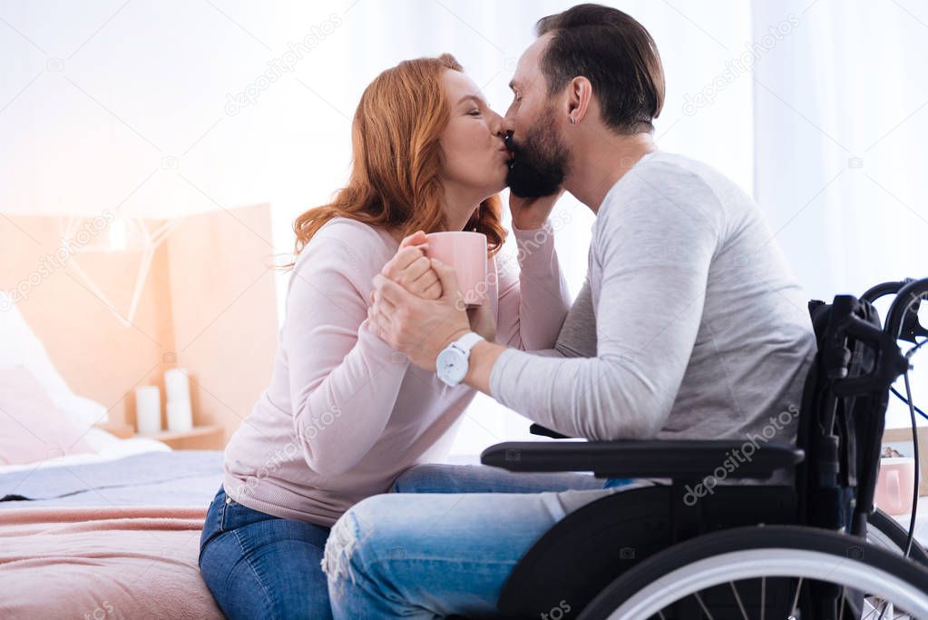 Inspired woman and paralyzed man kissing