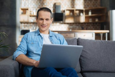 Neşeli esmer erkek onun laptop kullanma