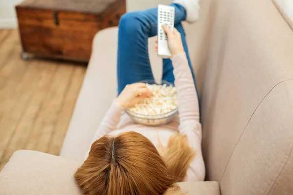 Блондинка отдыхает на диване с попкорном — стоковое фото