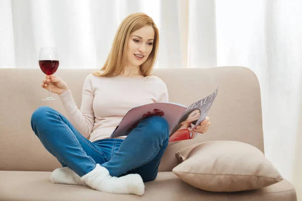 Donna ispirata guardando attraverso una rivista di moda — Foto Stock