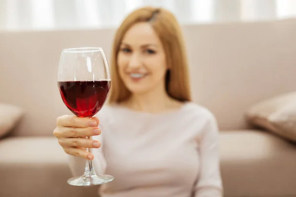 Улыбающаяся женщина держит бокал или вино — стоковое фото