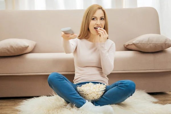 Härlig kvinna äta popcorn på golvet — Stockfoto