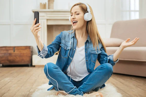 Mujer alegre cantando mientras escucha música — Foto de Stock