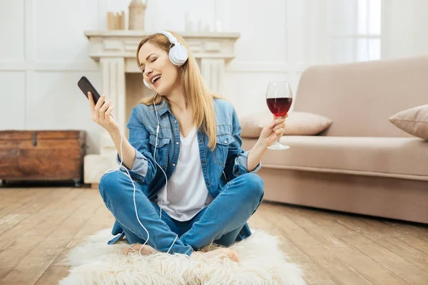 ワインのグラスと音楽を聴いて触発された女性 — ストック写真