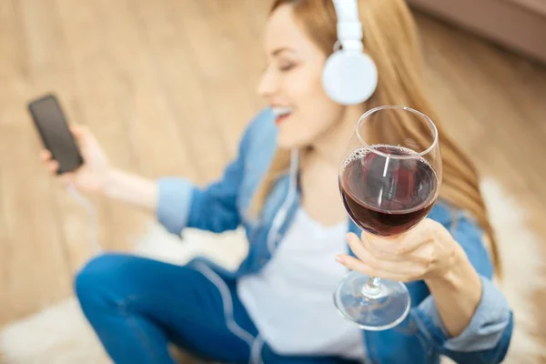 Mujer feliz bebiendo y escuchando música — Foto de Stock