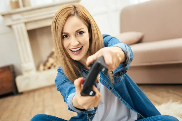 Счастливая женщина играет в игру с помощью дистанционного управления — стоковое фото