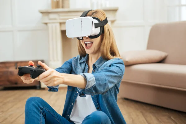 Pociąg kobieta sobie okulary wirtualnej rzeczywistości i za pomocą pilota zdalnego sterowania — Zdjęcie stockowe