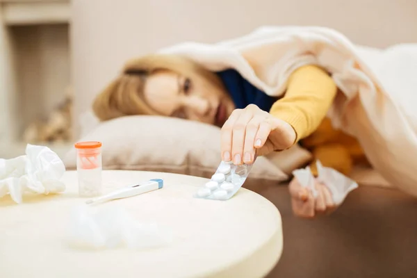 Mujer sin ánimo teniendo escalofríos y tomando pastillas — Foto de Stock