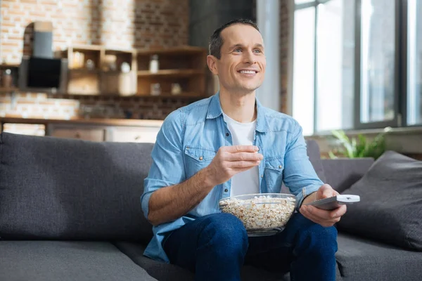 Glücklicher junger Mann schaut interessantes Programm — Stockfoto