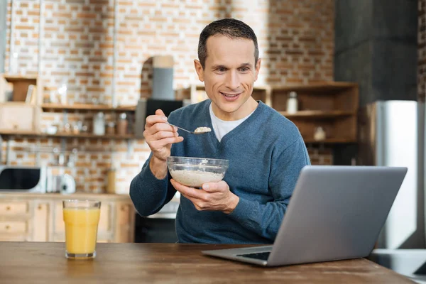 Handsome male person having morning dish