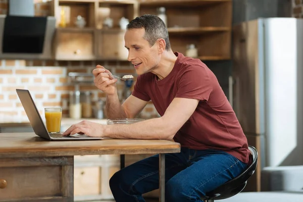 식사 하는 동안 비디오를 시청 하는 세심 한 남자 — 스톡 사진