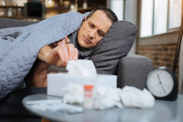 Sick male person lying on sofa — Stock Photo, Image