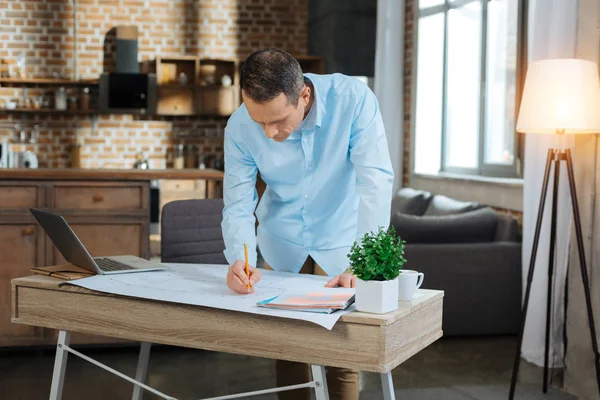 Concentrated engineer standing at his workplace