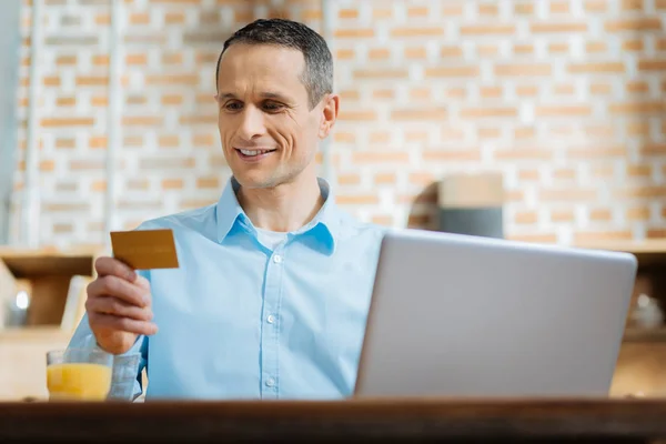 Positivo encantado homem usando seu cartão de crédito — Fotografia de Stock