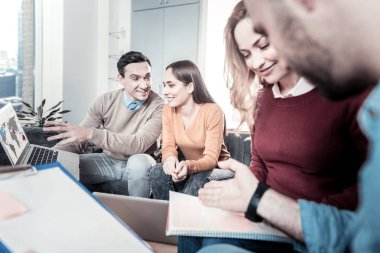 Tartışmak ve laptop ve defter ile çalışan genç bakış açısı çalışanlar.